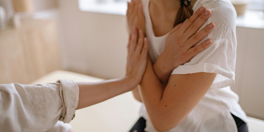 A girl with her arm crossed over her chest recieves chiropractic care from a female doctor