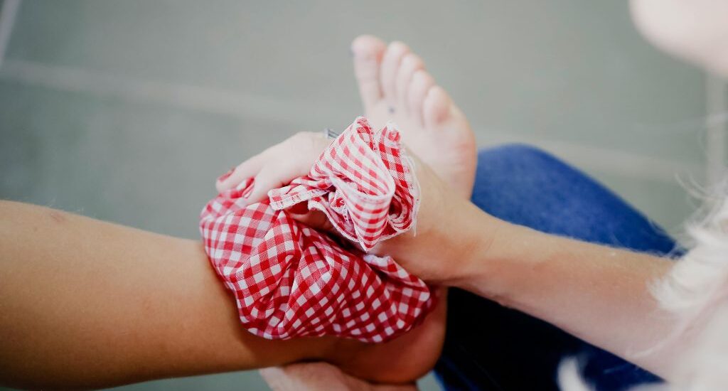 Icing an Ankle Injury with a cold pack in red fabric