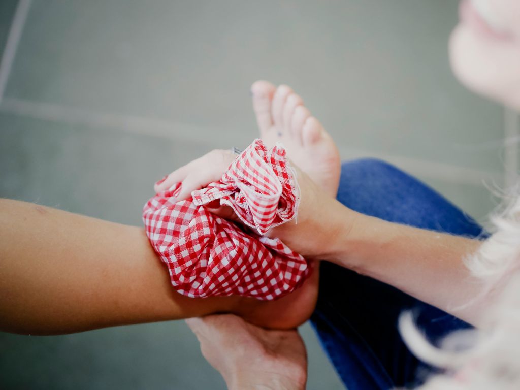 Icing an Ankle Injury with a cold pack in red fabric